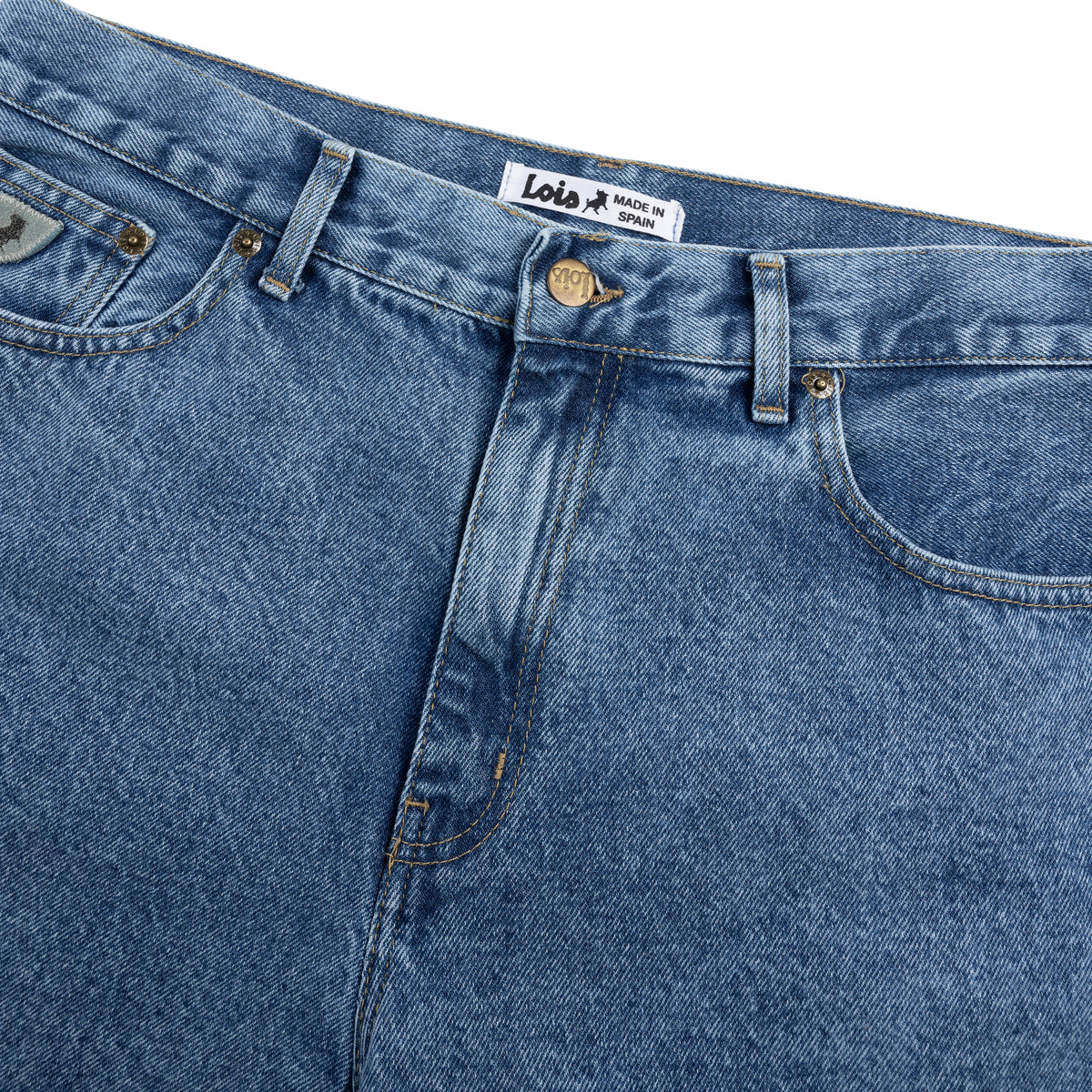 Close-up of blue jeans with a visible brand label on a white background