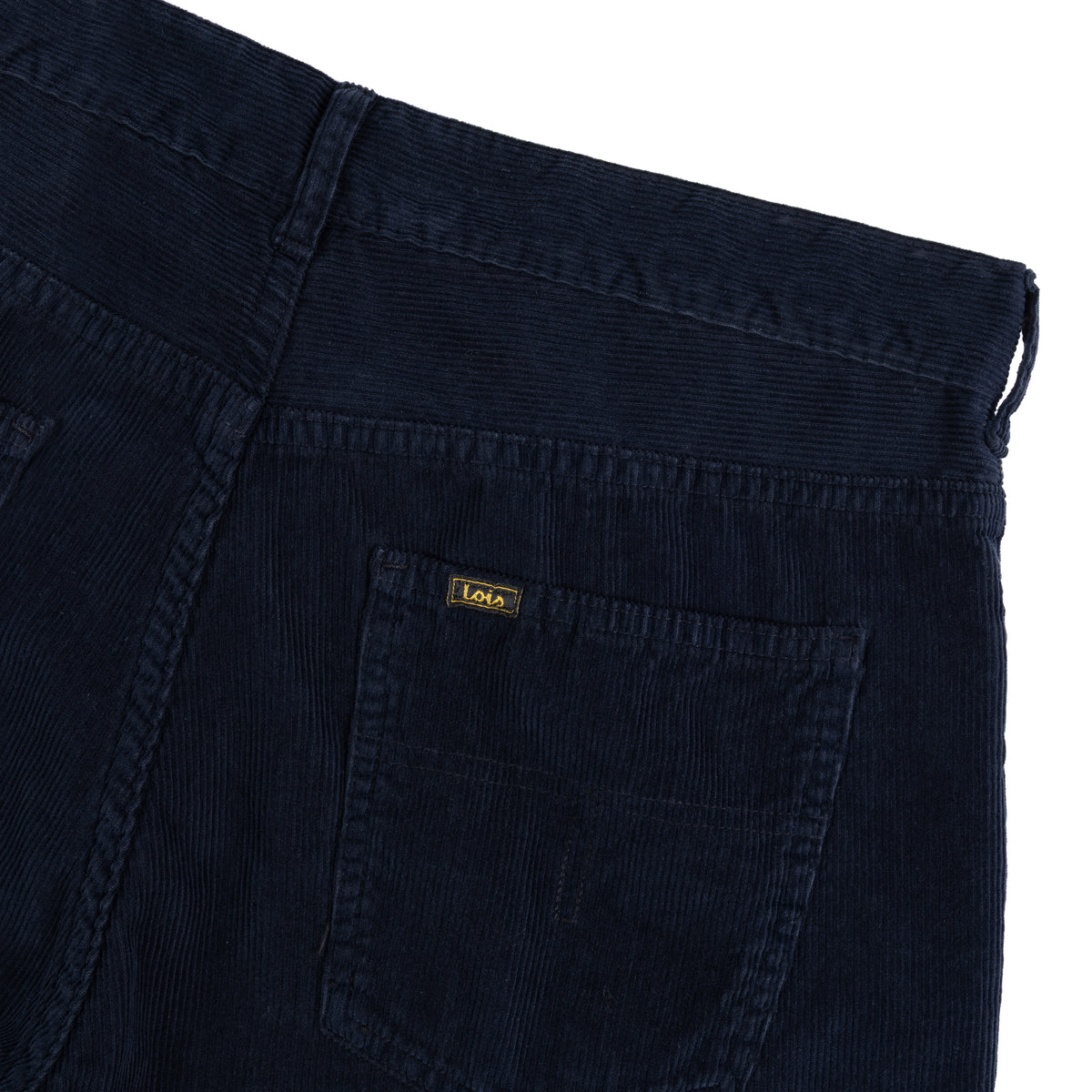 Close-up of navy blue cord trousers showing the back pocket with small branding Lois tab, shot on a white background