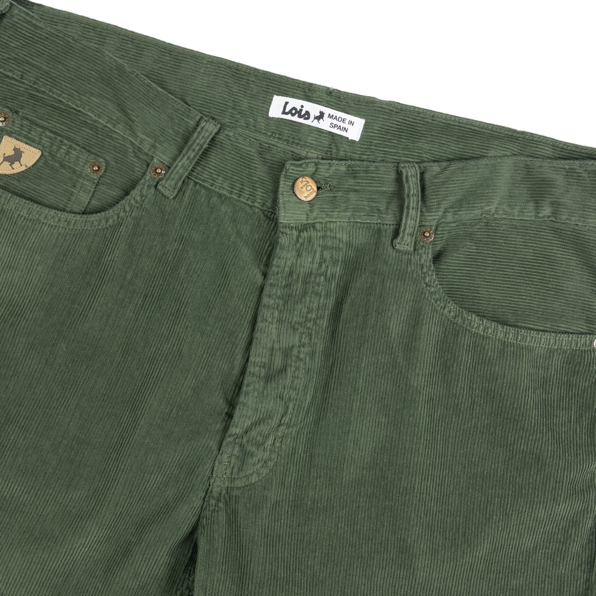 Close-up of corduroy pants in dried herb showing the waistband, belt loops, button closure, front pocket, and a small triangular logo patch on the coin pocket. The waistband label reads 'Lois' and 'MADE IN SPAIN'.