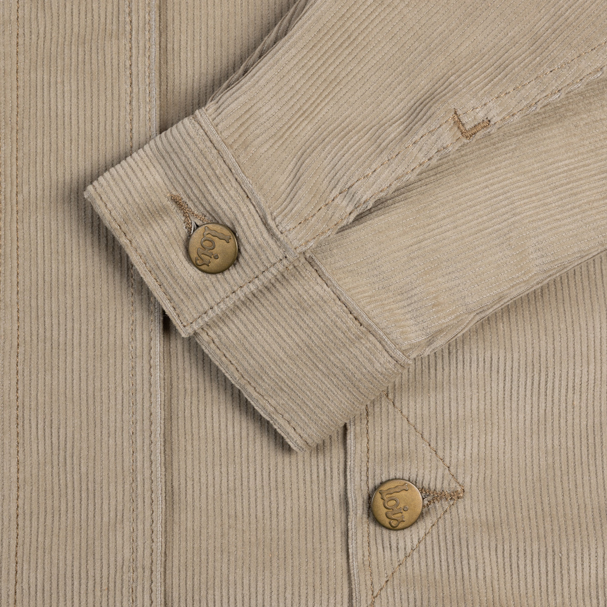 Close-up of a beige corduroy jacket with button details
