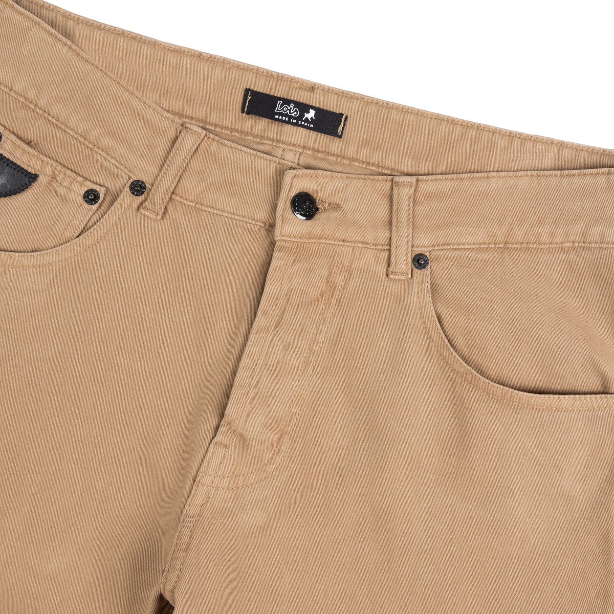Close-up of tobacco brown moleskin jeans showing the waistband, button closure, belt loops, front pocket, and inner label with the brand name 'Lois'.