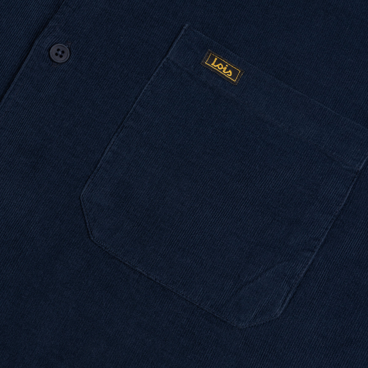 Close-up of a dark navy corduroy button-up shirt pocket with a small gold 'Lois' brand label on the chest.