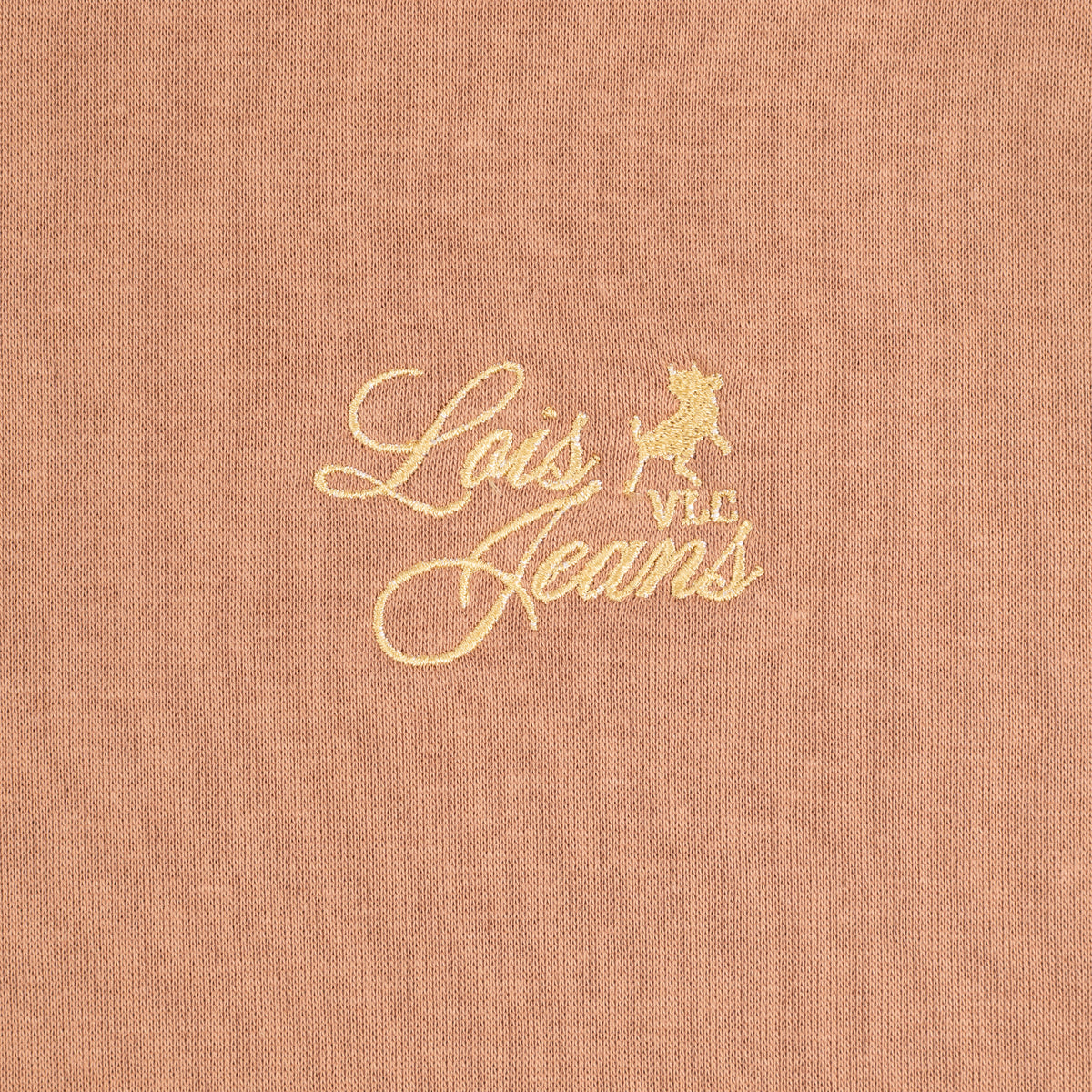 A close-up of a mocca brown sweatshirt with gold embroidered script reading 'Lois Jeans' and a small bull logo.