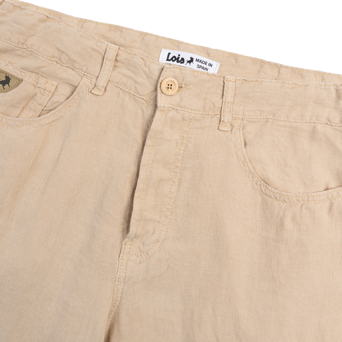 Close-up of beige pants with a Lois label on a white background